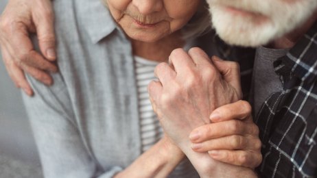 Bildet viser en eldre mann som holder rundt en eldre kvinne