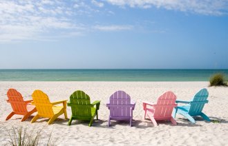 bildet viser tomme solstoler på en strand