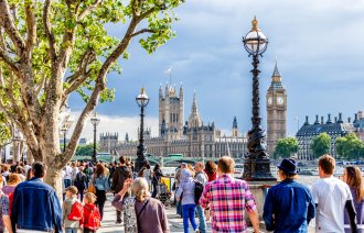 Bildet viser mennesker som går langs Themsen i London, med parlamentet i bakgrunnen