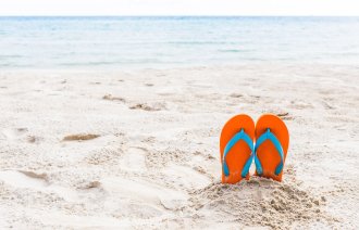 Bilde av strand med badesko stikkende opp av sanden