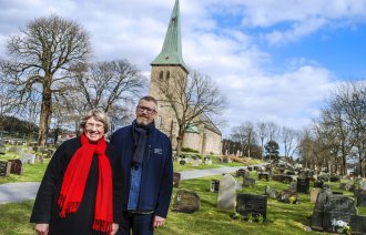 Sogneprestene Lisbeth Heie Gregersen og Petter Johannessen står på kirkegården foran Tune kirke