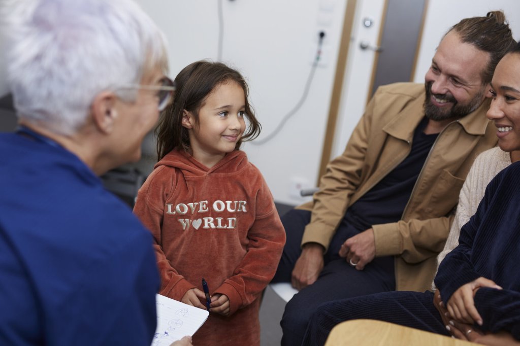 Bildet viser en familie som er på en konsultasjon hos et helsepersonell