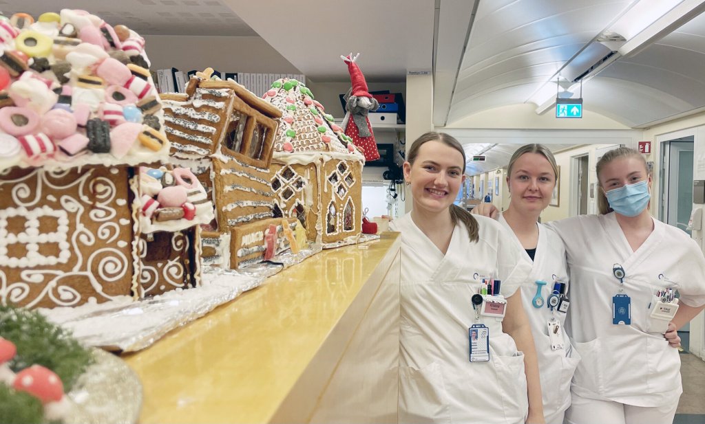 Bildet viser Kristine Opheim, Matilde Sørensen og Tonje Sverdrup Hansen ved siden av pepperkakehus.