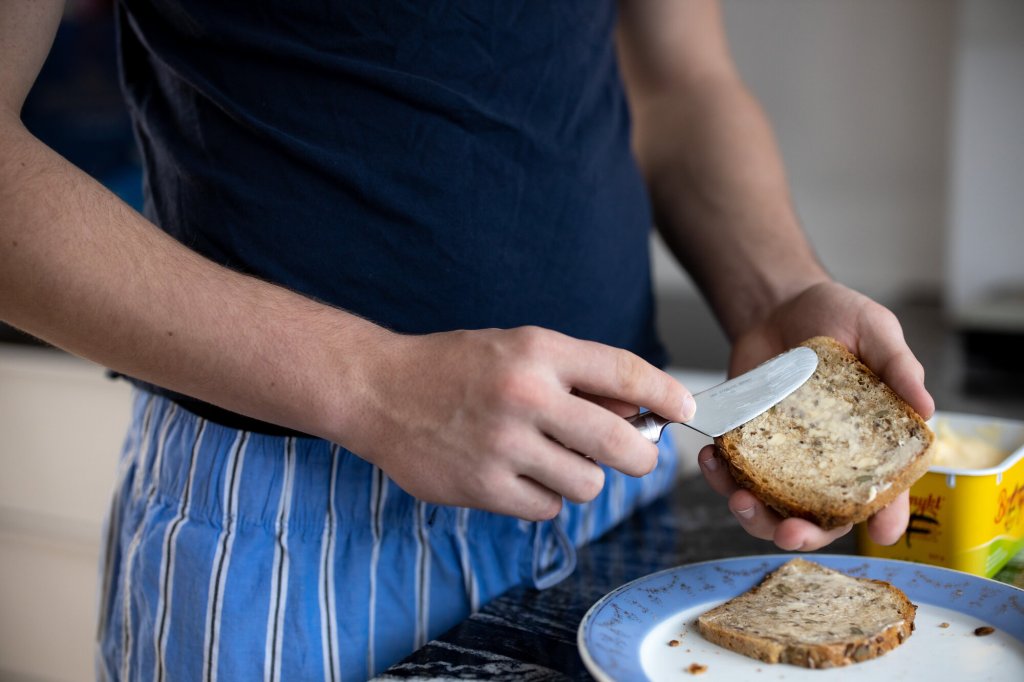 Gutt smører på brødskive