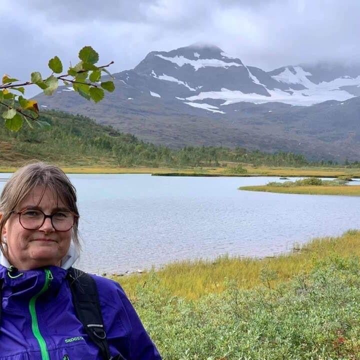 Bildet viser artikkelforfatteren på fjelltur foran et vann.