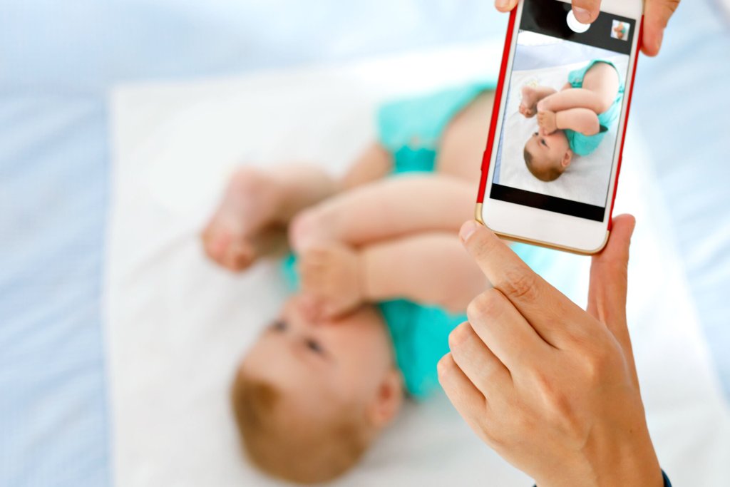 Noen tar bilde av en baby med mobiltelefonen.