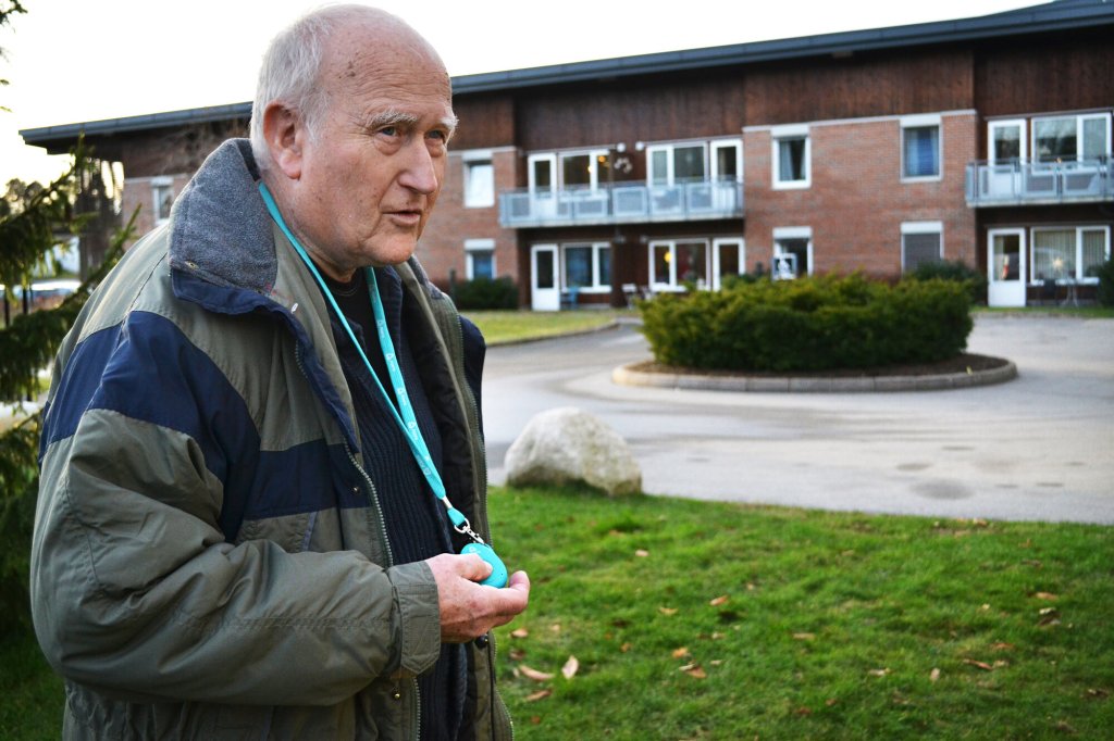 Hans Jakob Fønsterlien holder inne SOS-knappen på GPS-en han har rundt halsen.