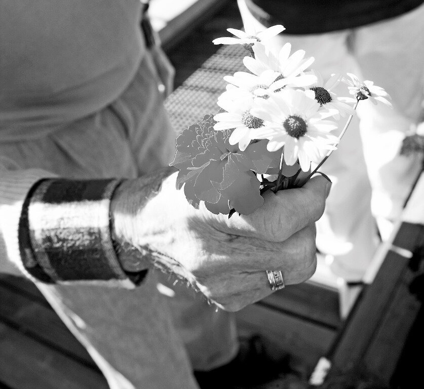 Eldre kvinne holder en blomsterbukett