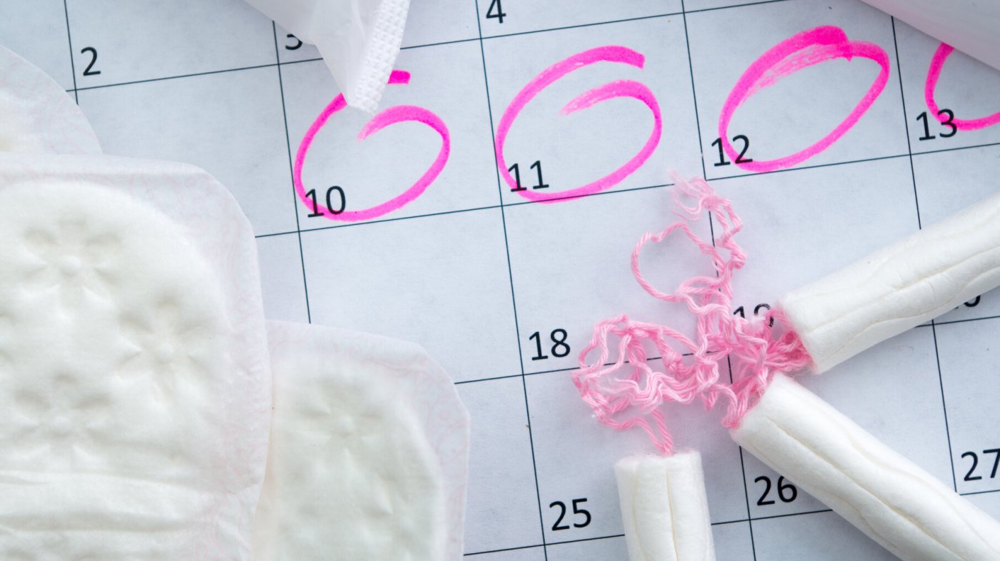 Kalender med tamponger og bind. Illustrere menstruasjonssyklus.