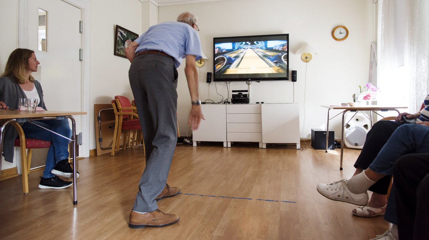 Bildet viser en eldre mann som spiller bowling med Kinect.