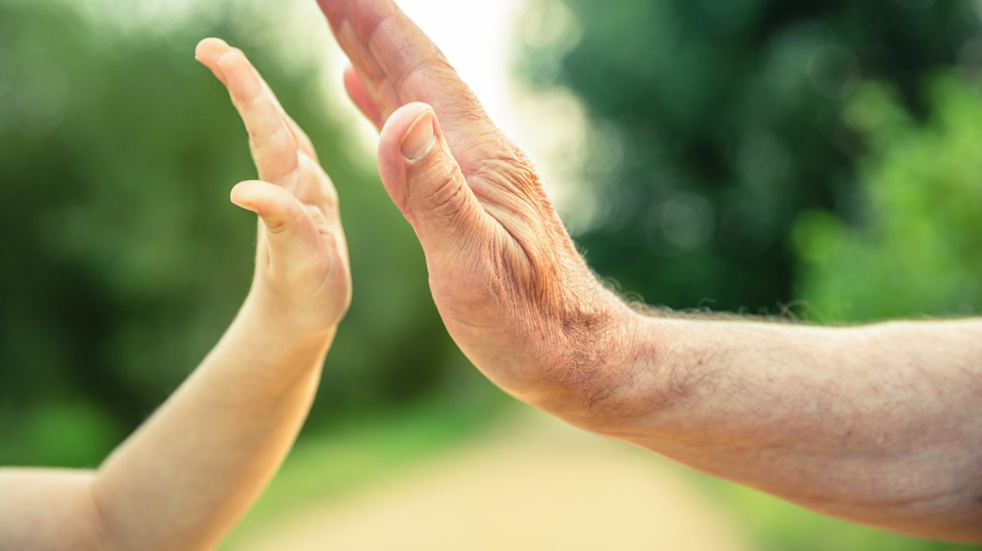 Bildet viser en voksen- og en barnehånd som slår "high five"