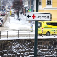 Bildet viser trafikkbildet i Oslo. Et skilt peker til Legevakta, mens en ambulanse kjører forbi